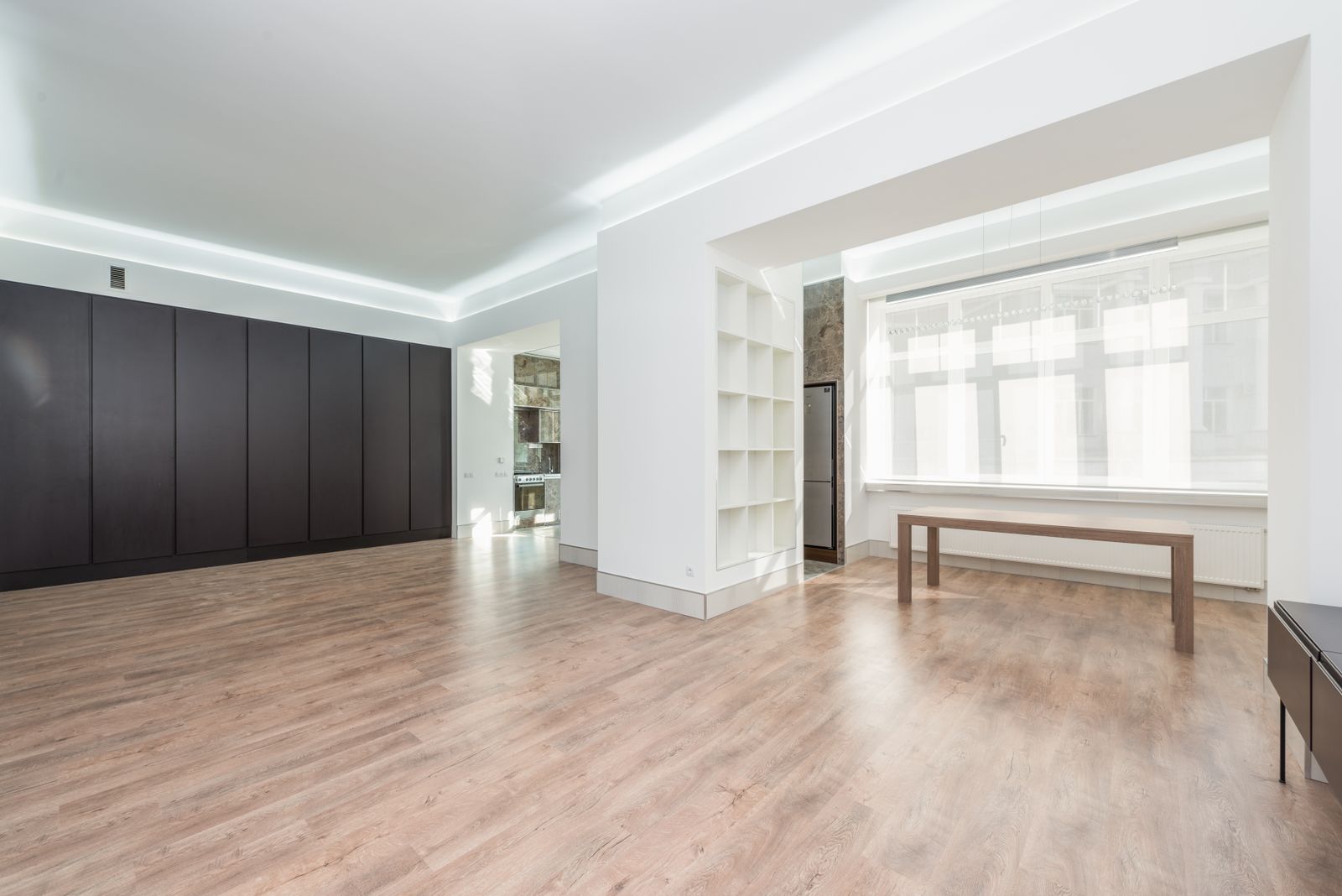 Ahşap zeminli, sade dolaplı, pırıl pırıl ve boş bir modern iç mekan
